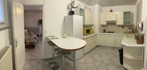 een keuken met witte kasten en een witte koelkast bij Maison plain pied 