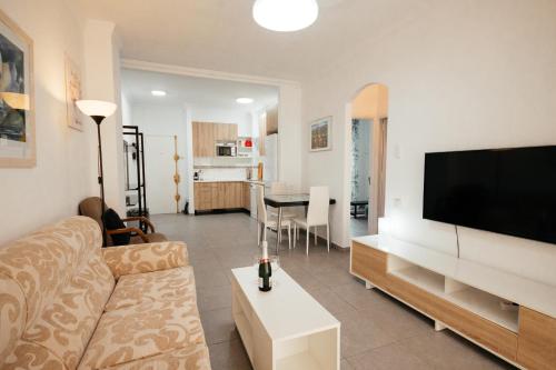 a living room with a couch and a flat screen tv at La puntilla de las canteras in Las Palmas de Gran Canaria