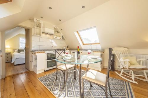 a kitchen and dining room with a glass table and chairs at Miller's Loft in Erpingham