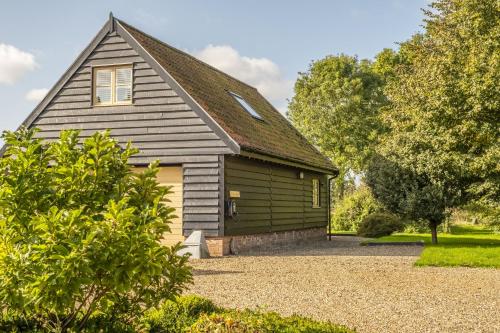a large house with a garage in front of it at Miller's Loft in Erpingham