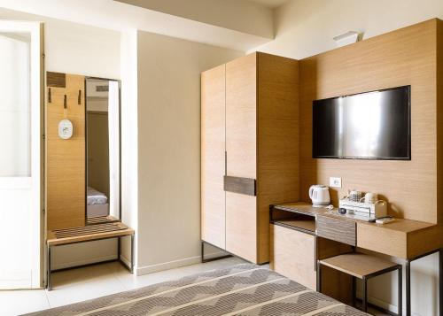 ガエータにあるAltavillaのベッド1台、薄型テレビが備わるホテルルームです。