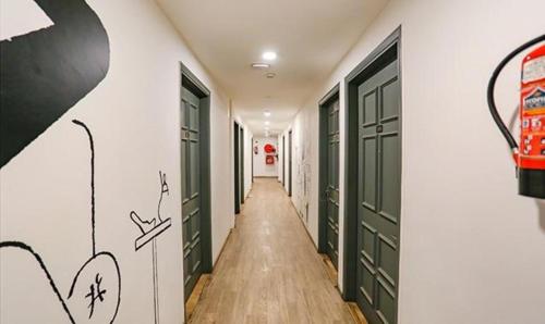 a hallway with green doors and graffiti on the walls at FabExpress Urban Residency Model Town in New Delhi