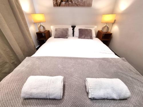 a bedroom with a large white bed with towels on it at Town Lodge in Newquay