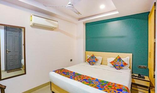 1 dormitorio con 1 cama con pared verde en FabExpress Rama, en Nueva Delhi