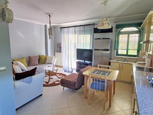 Orestiada的住宿－HOME SWEET HOME Διαμέρισμα 50τμ σε ήσυχη περιοχή，厨房以及带沙发和桌子的客厅。