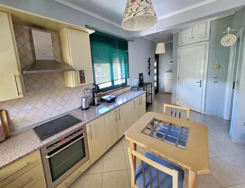 a kitchen with a table and a small kitchen with a stove at HOME SWEET HOME Διαμέρισμα 50τμ σε ήσυχη περιοχή in Orestiada
