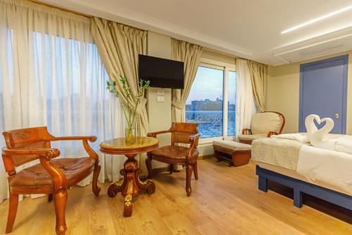 a bedroom with a bed and a table and chairs at Casa Sol Nile Cruise 4nt Lxr Saturday 3nt Asw Wednesday in Aswan