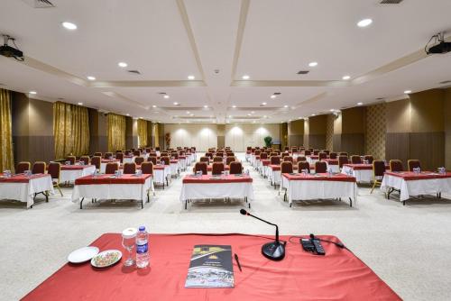 a large banquet hall with red and white tables and chairs at Anadolu Hotels Esenboga Thermal in Esenboga