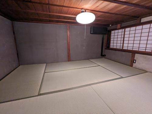an empty room with white mats and a light at KOZA River House 湯川邸 in Koza