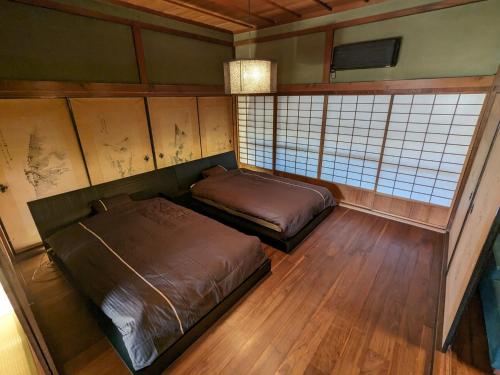 a bedroom with two beds in a room at KOZA River House 湯川邸 in Koza