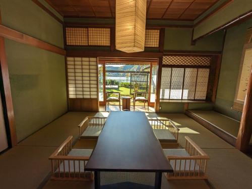 a room with a table and chairs in it at KOZA River House 湯川邸 in Koza