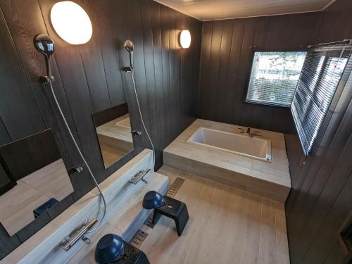 y baño con bañera y lavamanos. en KOZA River House 湯川邸, en Koza