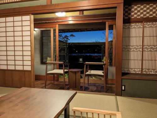 a room with a table and chairs and a window at KOZA River House 湯川邸 in Koza