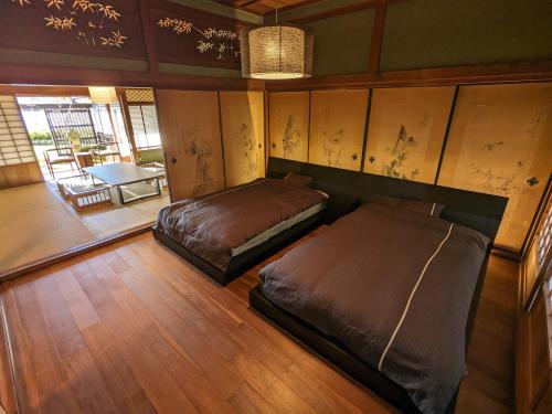 a bedroom with two beds in a room at KOZA River House 湯川邸 in Koza