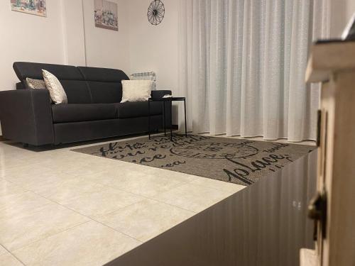 a living room with a black couch and a rug at Residence Outlet Vivaldi in Noventa di Piave