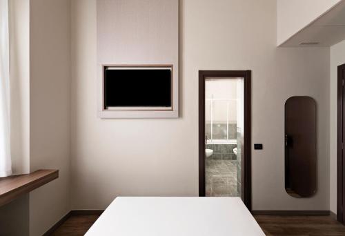 a bedroom with a bed and a television on the wall at Mokinba Hotels Montebianco in Milan