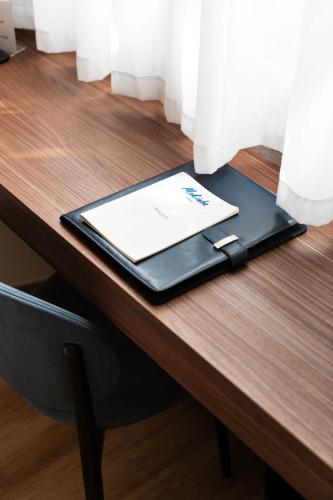 a tablet computer sitting on top of a wooden table at Mokinba Hotels Montebianco in Milan