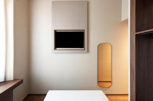 a bedroom with a bed and a tv on a wall at Mokinba Hotels Montebianco in Milan