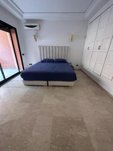 1 dormitorio con 1 cama en una habitación con armarios blancos en Grand duplex idéal pour famille, en Marrakech