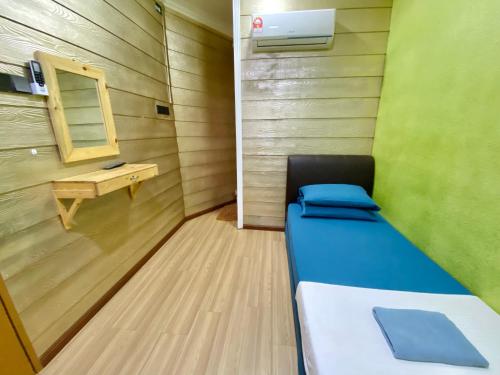 a small room with a bed and a mirror at Suza Hostel in Tumpat