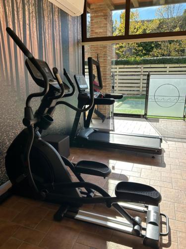 a gym with a treadmill and a table with a laptop at Luna Residence Hotel in Casalmaggiore