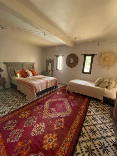 2 Betten in einem Zimmer mit einem roten Teppich in der Unterkunft Villa Des Arganiers in Essaouira