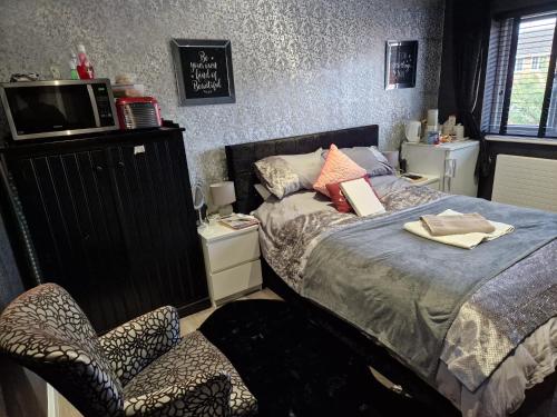 チェルムスフォードにあるLuxury on a Budgetのベッドルーム(ベッド1台、椅子、テレビ付)
