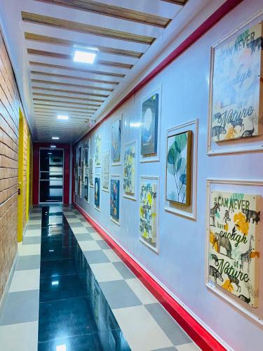 a hallway with a tile floor and pictures on the wall at Suza Hostel in Tumpat