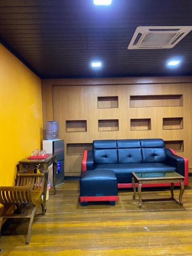 a living room with a blue couch and chairs at Suza Hostel in Tumpat
