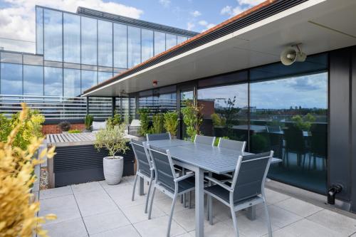 a table and chairs on a patio with a view at Dao by Dorsett West London in London