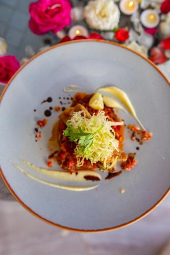 a white plate with a dish of food on a table at RIAD GOLD in Azrou