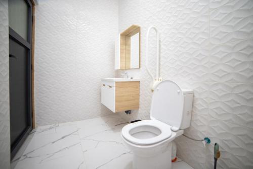 a white bathroom with a toilet and a sink at RIAD GOLD in Azrou