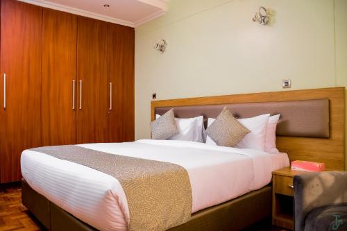 埃尔多雷特TJ's Boutique Hotel的卧室里有一张带木质床头板的大床