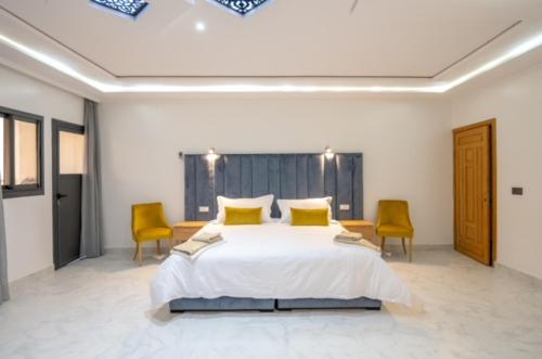 um quarto com uma cama grande e 2 cadeiras em RIAD GOLD em Azrou