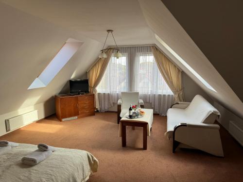 a attic room with a bed and a tv at Politechnika Warszawska Ośrodek Wypoczynkowy in Sarbinowo