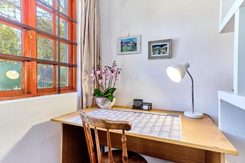 una oficina con escritorio y lámpara en Lonehill - Deluxe Garden Cottage 2 en Sandton