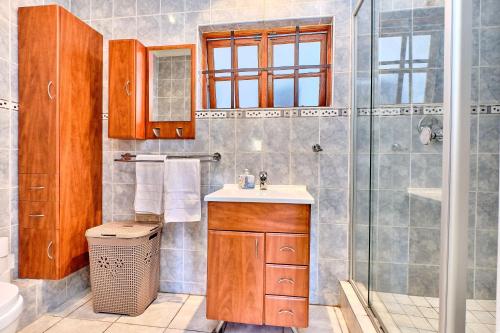 ein Bad mit einem Waschbecken und einer Dusche in der Unterkunft Lonehill - Deluxe Garden Cottage 2 in Sandton