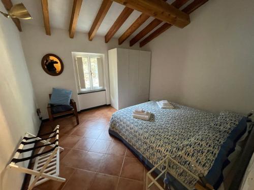 a bedroom with a bed and a chair and a window at Casa dell'Arco 31 in Camogli