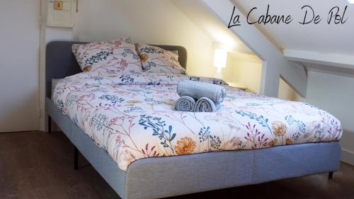 a bed with a blanket with a camera on it at La Cabane De Pol in Dunkerque