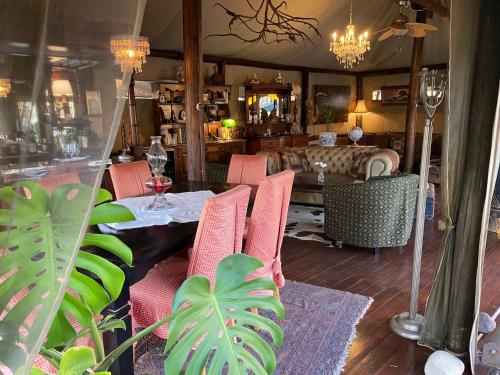 a dining room with pink chairs and a table at Out in Africa Wildlife Lodge in Dinokeng Game Reserve