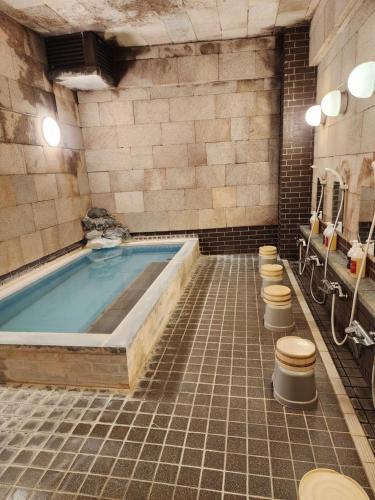a bathroom with a jacuzzi tub with four toilets at Hakuba Hotel Hana-no-Sato in Hakuba