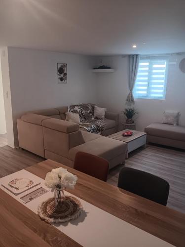 a living room with a couch and a table at Gîte et SPA Au Secret Du Bonheur in Pouilly-sur-Serre