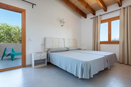 a bedroom with a bed and a large window at Es Regalo - Pérgola in Porto Cristo
