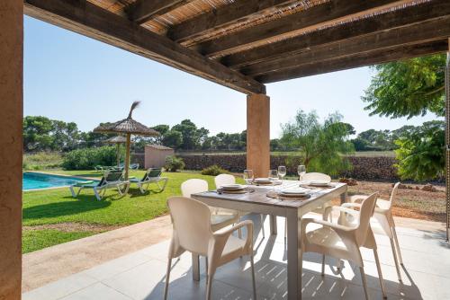 a dining table and chairs on a patio at Es Regalo - Pérgola in Porto Cristo