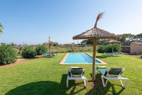 a yard with two chairs and a swimming pool at Es Regalo - Pérgola in Porto Cristo
