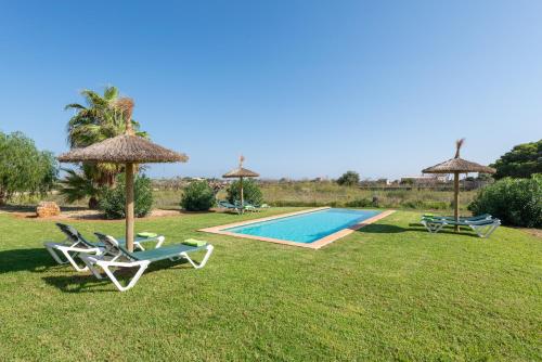 a pool with two lawn chairs and umbrellas at Es Regalo - Pérgola in Porto Cristo