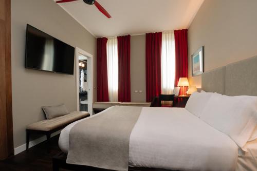 a hotel room with a bed and a flat screen tv at 10 KEYS MILANO in Milan