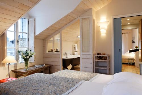 a bedroom with a bed and a bathroom with a sink at Le Lodge Kerisper in La Trinité-sur-Mer
