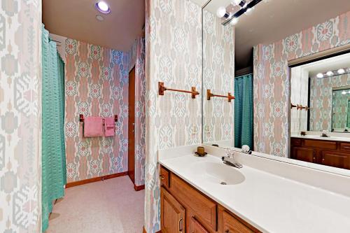 W łazience znajduje się umywalka, wanna i lustro. w obiekcie Townsend Place B206 w mieście Beaver Creek