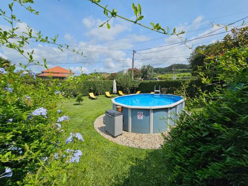 a hot tub in a yard with a garden at Casa do Lima Alojamento Local Registo134359.AL in Brandara